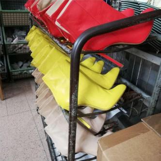 Multi-tiered metal rack with unfinished boots in production - Kendrick manufacturing process